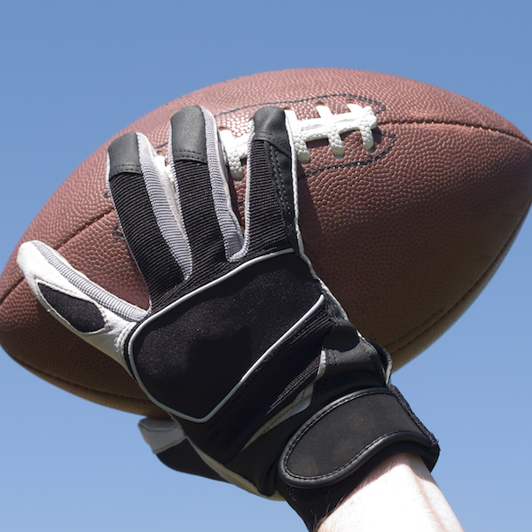 A close-up of a hand that is poised to throw a football